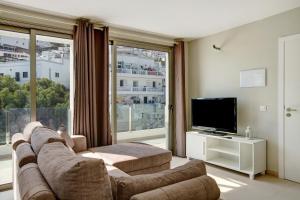 a living room with a couch and a flat screen tv at Atico Albamar in Puerto de Mogán