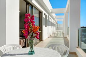 a vase of flowers sitting on a table on a balcony at Atico Albamar in Puerto de Mogán
