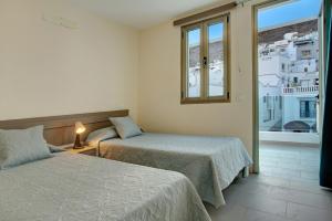 a hotel room with two beds and a window at Atico Albamar in Puerto de Mogán
