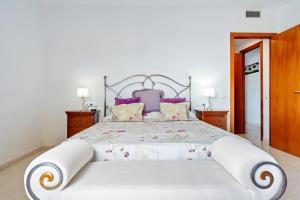 a bedroom with a large white bed with purple pillows at Ática Blue Sea in Cubelles +20 photos