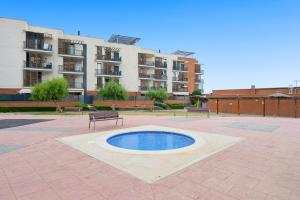 a small pool in the middle of a courtyard with benches at Ática Blue Sea in Cubelles