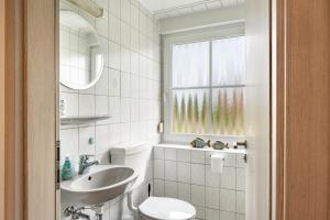 a bathroom with a sink and a toilet and a window at Kleiner Leuchtturm - Steuerbord in Fehmarn +26 photos