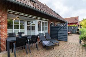 a patio with a black dining table and chairs at Kleiner Leuchtturm - Steuerbord in Fehmarn