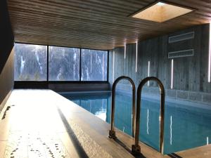 a swimming pool in a building with windows at Chalet du Saix in Châtel
