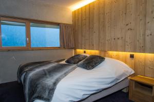 a bedroom with a bed with two pillows on it at Chalet du Saix in Châtel +21 photos