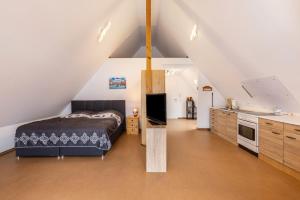 a attic bedroom with a bed and a kitchen at Hohenzollern in Gammertingen