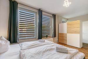 a bedroom with a large bed and two windows at Hotel zur Panke Wohnung 1 in Kolonie Röntgental