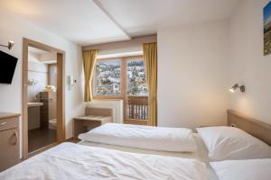 a bedroom with two white beds and a window at Runcac Apt Salt in San Vigilio Di Marebbe