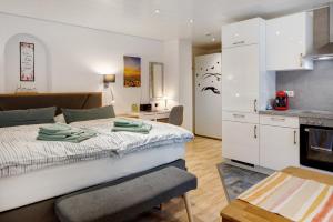 a bedroom with a large bed and a kitchen at Gelis Ferienwohnung in Ihringen