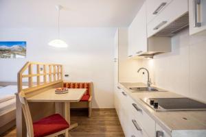 a small kitchen with a table and a sink at Runcac Apt Salt in San Vigilio Di Marebbe