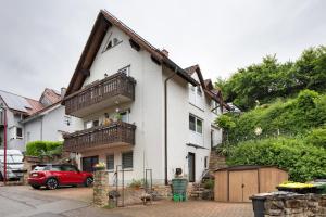 a house with a red car parked in front of it at Gelis Ferienwohnung in Ihringen