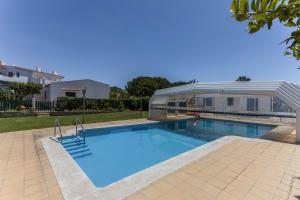 a swimming pool in front of a house at Villa Morena in Albufeira