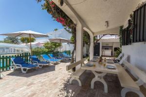 a patio with a table and chairs and umbrellas at Villa Morena in Albufeira