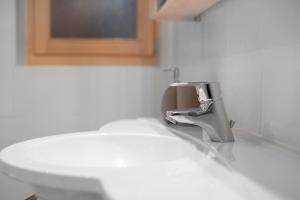 a bathroom with a sink and a faucet at Rafaser - Apartment Rustika in Feldthurns +14 photos