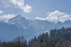 a view of a mountain range with trees and clouds at Ferienwohnung Bergpanorama in Garmisch-Partenkirchen