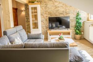 a living room with a couch and a tv at Ferienwohnung Bergpanorama in Garmisch-Partenkirchen