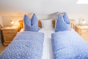 two beds with blue pillows in a bedroom at Ferienwohnung Bergpanorama in Garmisch-Partenkirchen