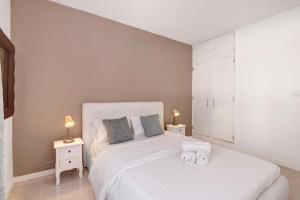 a bedroom with a white bed with two towels at Apartamento Brisas Do Mar in Porches