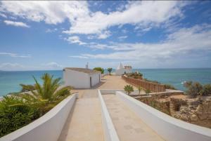 a walkway leading to a beach with the ocean at Apartamento Brisas Do Mar in Porches