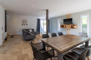 a living room with a wooden table and chairs at Le Séchoir in Saint-Amand-de-Coly