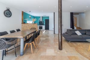 a dining room and living room with a table and chairs at Le Séchoir in Saint-Amand-de-Coly