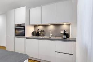 a kitchen with white cabinets and a sink at Fewo im Eichengrund in Rheinhausen