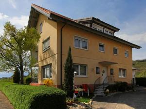 a large house with a tree in front of it at Ferienwohnung Graf in Vogtsburg