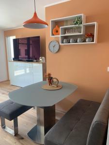 a dining room with a table and a clock on the wall at Apartment Bergzeit Sterzing in Vipiteno