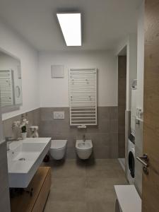 a bathroom with a sink and a toilet and a tub at Apartment Bergzeit Sterzing in Vipiteno +10 photos