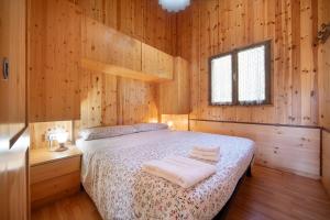 a bedroom with a bed in a wooden cabin at Casa Genziana in Barzio