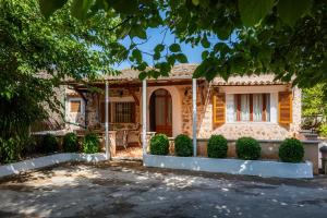 a house with a tree in front of it at Can Tiro in Islas Baleares