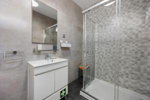 a bathroom with a glass shower and a sink at Apartamento Carrapateira in Bordeira