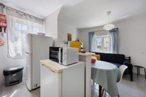 a kitchen with a white refrigerator and a table at Apartamento Carrapateira in Bordeira +14 photos