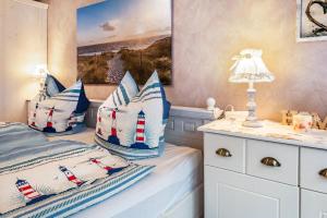 a bedroom with a bed with blue and white pillows at Ferienwohnung Freesenhuus in Wangerland