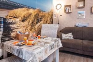 a table with food and drinks on it next to a couch at Ferienwohnung Freesenhuus in Wangerland