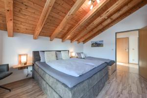 a bedroom with a large bed and wooden ceilings at Ferienwohnung Alpenvogel in Sonthofen