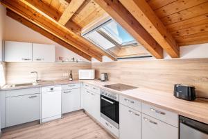 a kitchen with white cabinets and a skylight at Ferienwohnung Alpenvogel in Sonthofen