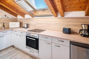 a kitchen with white cabinets and a skylight at Ferienwohnung Alpenvogel in Sonthofen +20 photos