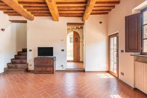 an open living room with wooden ceilings and a television at La Casina di Elisa in Montecarlo