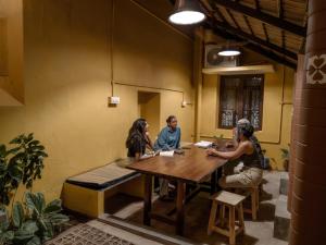 a group of people sitting around a table in a room at Maison Monty in Pondicherry