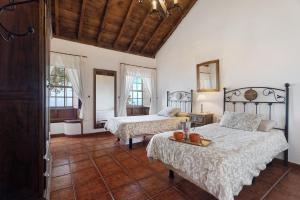 a bedroom with two beds and two windows at Casa El Naranjo Viejo in Tijarafe
