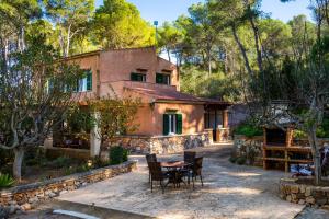 a house with a table and chairs in front of it at Finca Perello in Felanitx