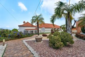 a house with palm trees and a brick driveway at Casa El Naranjo Viejo in Tijarafe