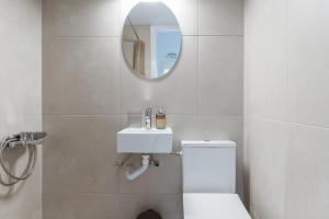 a bathroom with a white toilet and a mirror at Stenies Little Nook in Andros