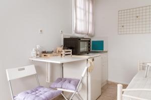 a small kitchen with a table and a microwave at Stenies Little Nook in Andros