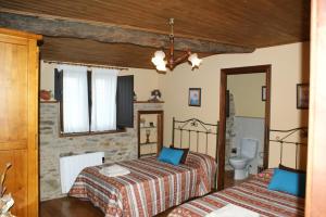 a bedroom with two beds and a bathroom at O Bolaño Apt 1 in Villarino de Conso