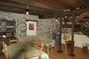 a living room with a table and a stone wall at O Bolaño Apt 1 in Villarino de Conso