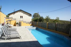 a swimming pool with lounge chairs next to a fence at O Bolaño Apt 1 in Villarino de Conso +34 photos