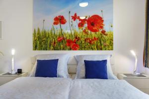 a bedroom with red poppies painting on the wall at Apartment Nordstern in Baabe