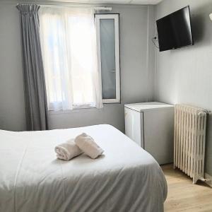 a bedroom with a bed with two towels on it at Hotel Wilson Square in Toulouse +5 photos
